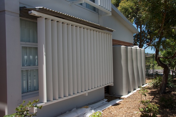 RCC11 Louvres on the building's western side are adjustable to all in sun in winter and exclude it in summer. Beside the louvres is a 5000 litre water storage that surge fills the large water tank that flushed the toilets.