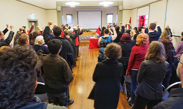 Attendees stand to sing the anthem of the world socialist movement, the International, a suitable farewell song in recognition of John Percy’s contribution.